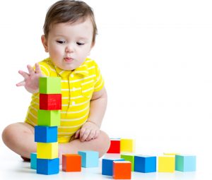interested infant playing with building blocks